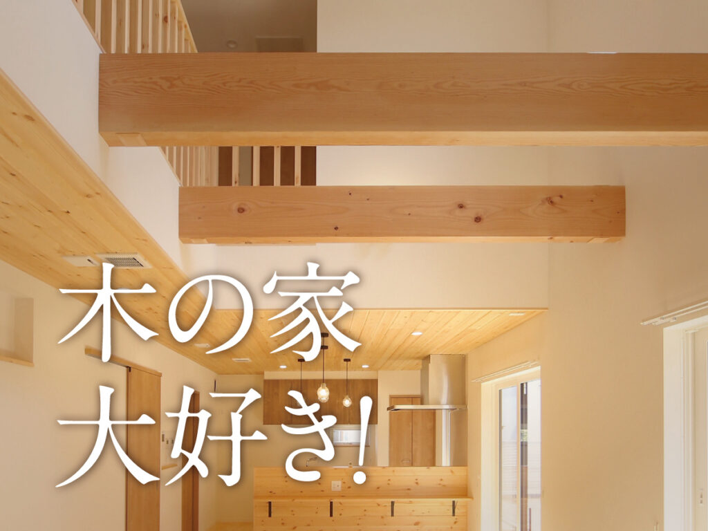 木の梁と吹き抜けを生かしたLDK。「木の家 大好き！」の文字入り