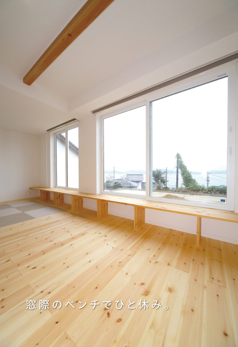 大きな窓のそばに、ご夫婦こだわりの造作ベンチ。木の床と梁に囲まれて、ゆったり過ごせる居場所をつくりました。