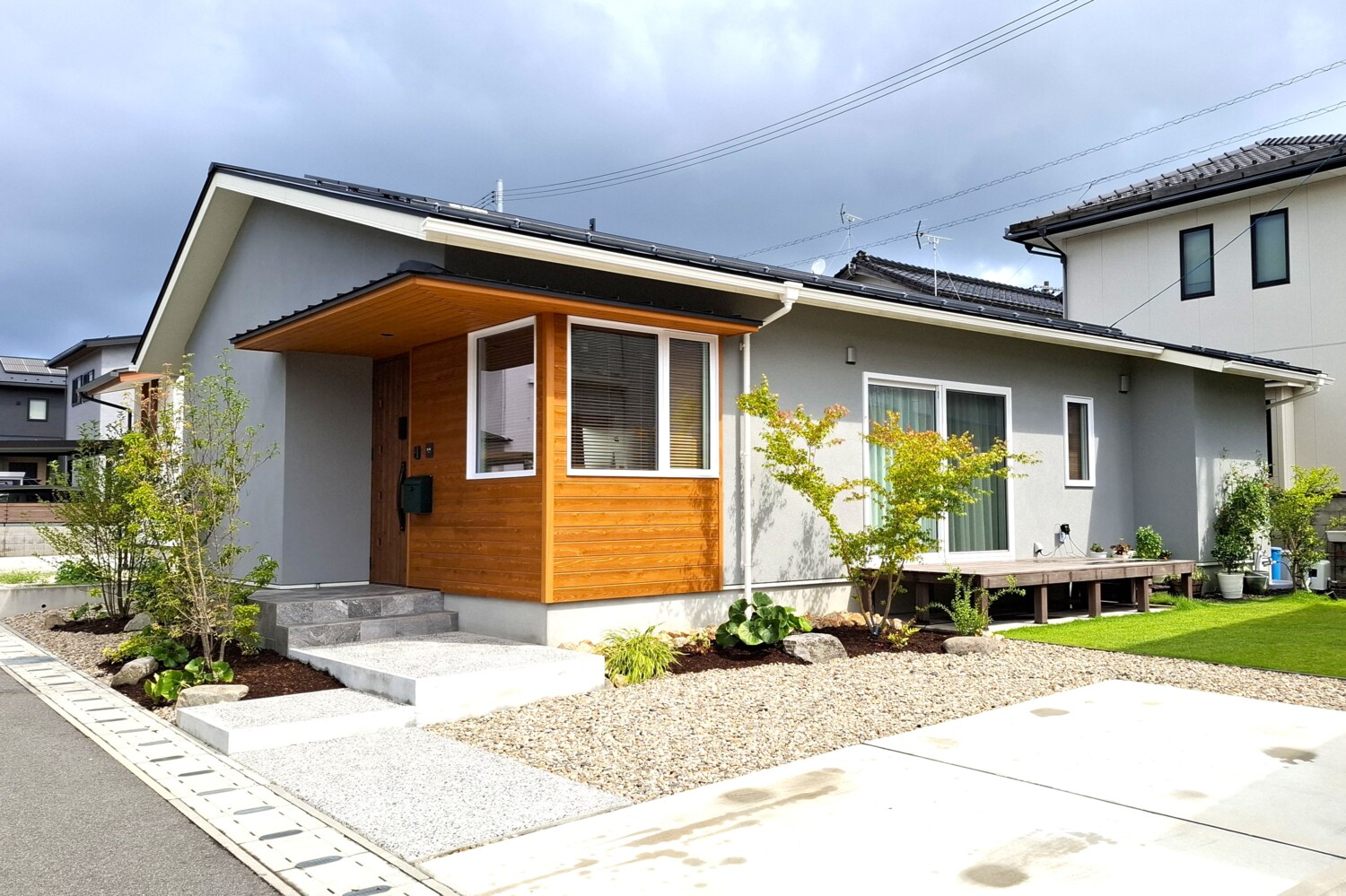 塗り壁と木、庭がつながる平屋の外観